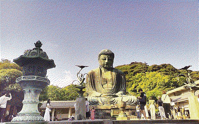 A big buddha statue with people in front