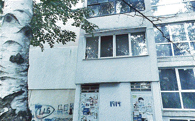 The ground floor of an apartment block with graffiti that reads “1914”