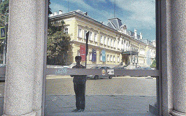 A reflection of a boy with a yellow building in the background