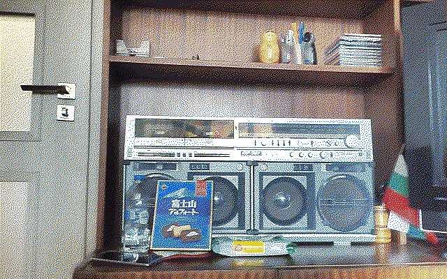 A big cassette stereo system with a small box of chocolates in front of it