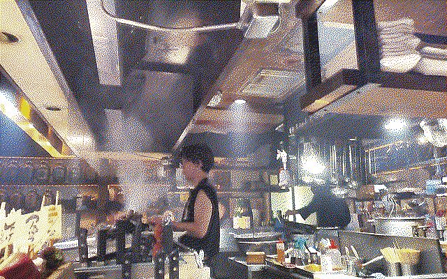 chef cooking skewers in a smoky room